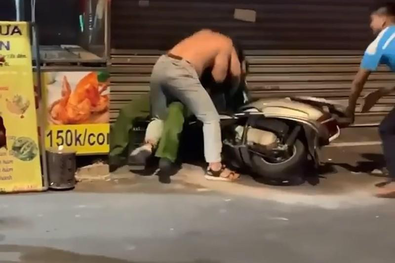 Người đàn ông đã tấn công khiến công an té xuống đường. Ảnh chụp từ clip Người đàn ông đã tấn công khiến công an té xuống đường. Ảnh chụp từ clip