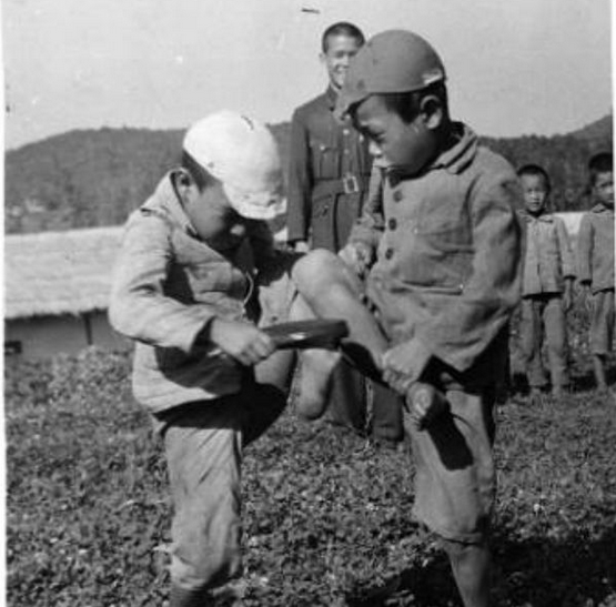 Hình ảnh hai học sinh Triều Tiên vui đùa trước sân trường. Lúc bấy giờ, ngôn ngữ Triều Tiên bị cấm dùng trong hệ thống trường học, đồng thời người dân phải dùng tiếng Nhật thay thế