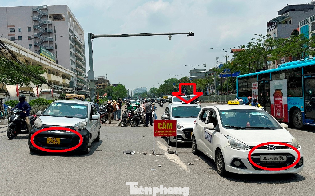 Nguyên nhân ùn tắc do có nhiều xe taxi dừng đỗ, chờ đón khách trên đường đoạn trước cổng bệnh viện Bạch Mai. Các xe này trên biển số đều bị làm mờ ít nhất từ một đến hai chữ số.