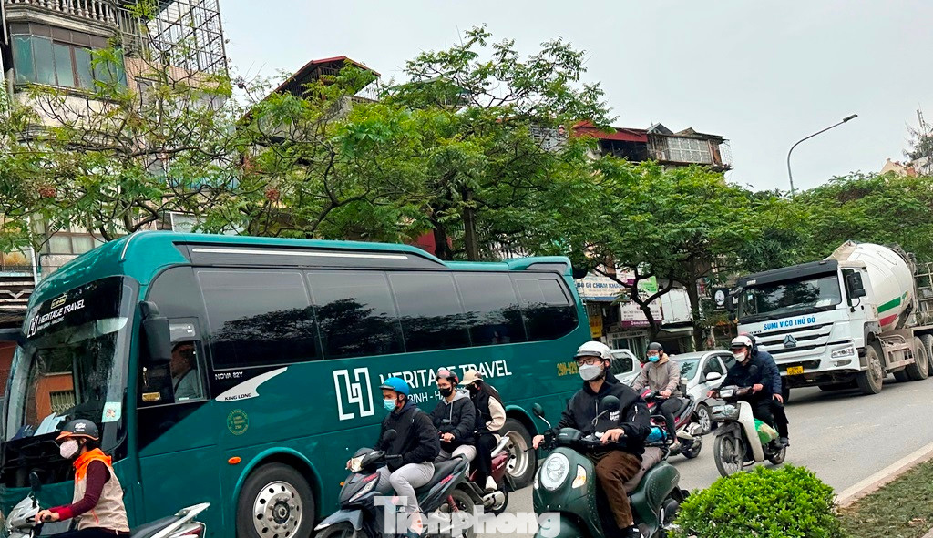 Ngoài ra, theo ghi nhận của PV Tiền Phong, chiều đường Giải Phóng - Lê Duẩn hiện còn tình trạng xe tải, xe công trường và xe khách hoạt động bất kể thời gian. Trong ảnh: Xe khách và xe bồn bê tông nối đuôi nhau qua nút Giải Phóng - Đại Cồ Việt - Lê Duẩn vào giờ cao điểm sáng 1/4.