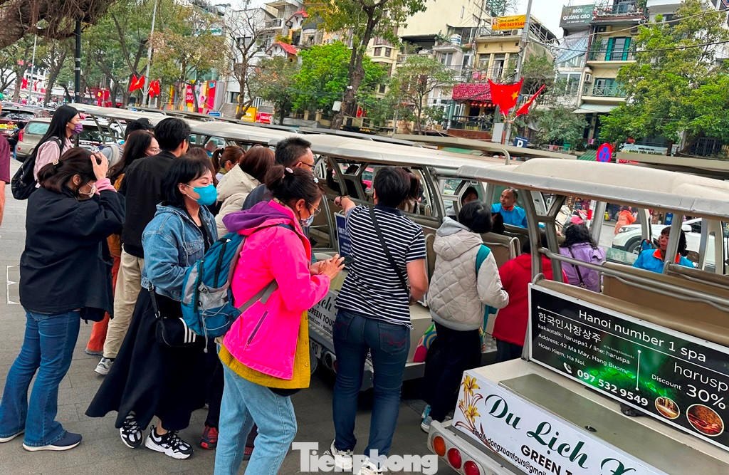 Với xe điện chở khách du lịch tại Hà Nội đang hoạt động tại khu vực Hồ Hoàn Kiếm và khu phố cổ.