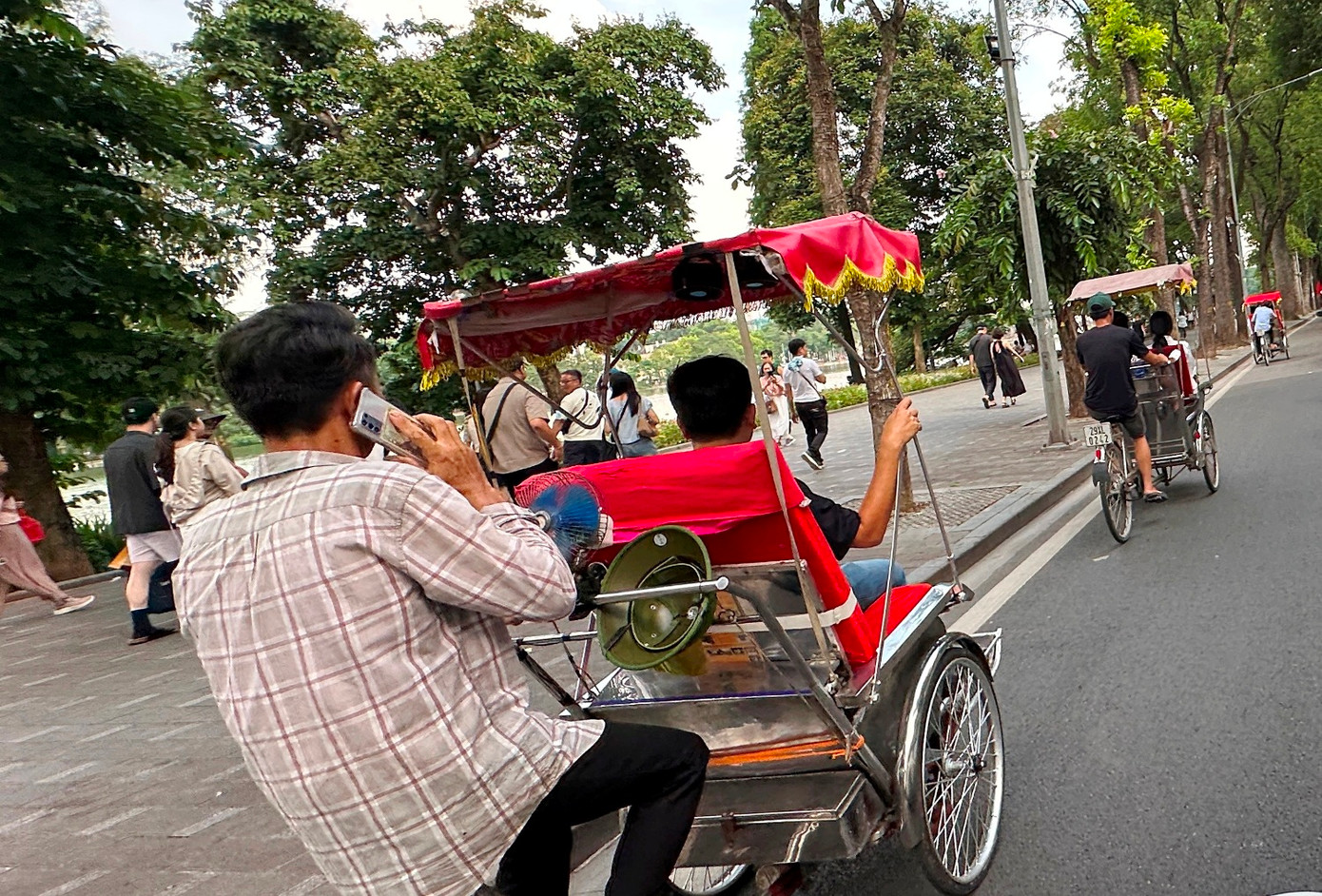 Lái xe xích lô vừa chở khách tham gia giao thông, vừa nghe điện thoại Lái xe xích lô vừa chở khách tham gia giao thông, vừa nghe điện thoại