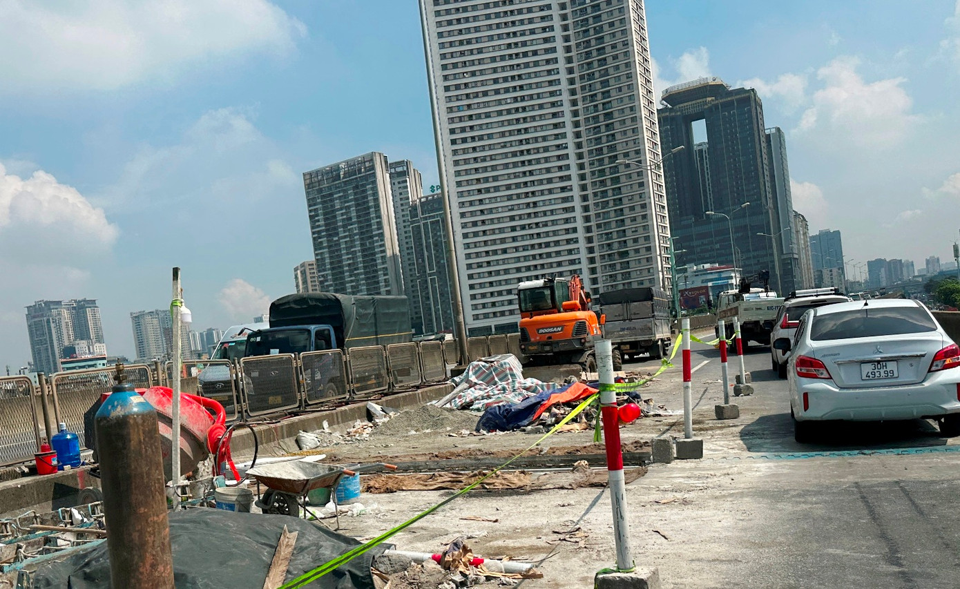 Mặc dù theo yêu cầu của Sở Xây dựng, thời gian thi công sửa chữa khe co giãn và mặt đường ở đường Vành đai 3 chiều Big C - Mai Dịch đã hết, nhưng trong sáng 5/7 hàng rào vẫn nằm yên, công trường thi công ngổn ngang và chiếm hơn nửa lòng đường.