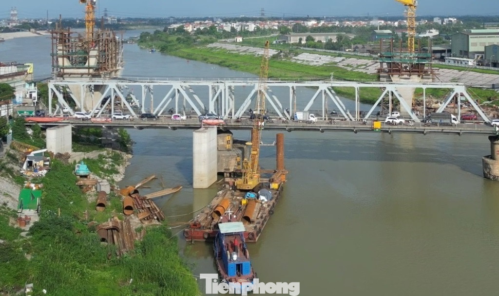 Thi công ở địa hình lòng sông sâu, các nhà thầu phải dùng sà lan chuyên dụng để bố trí máy móc, cẩu xây dựng hoạt động thi công cả đêm, ngày.