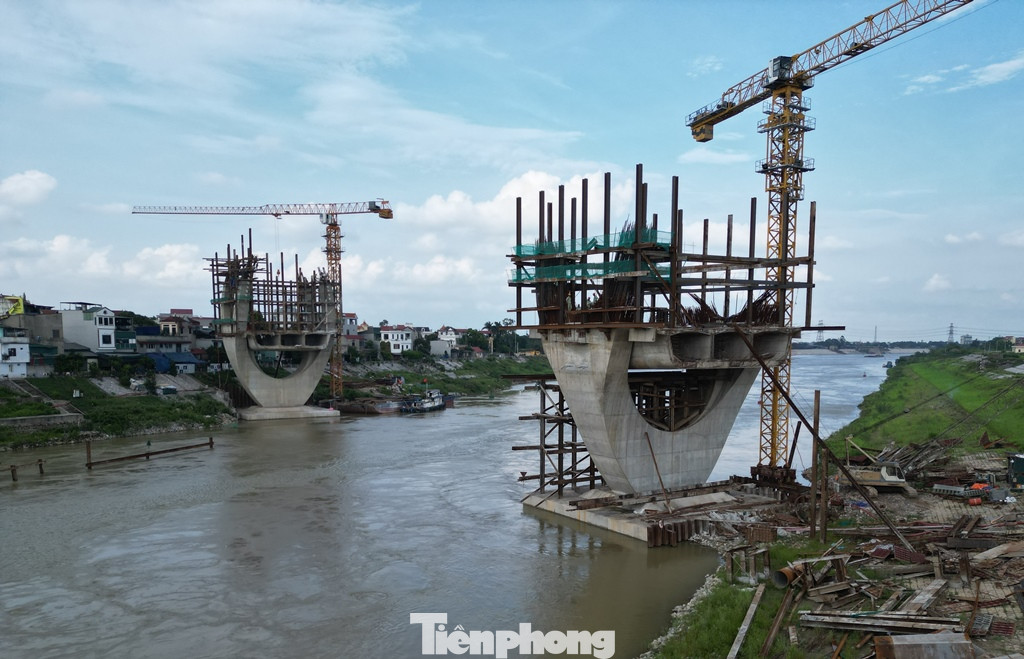 Trao đổi với PV Tiền Phong, ông Trần Anh Tuấn, Cty Cổ phần Tập đoàn Đạt Phương (nhà thầu chính) thi công dự án cho biết, do dầm cầu thi công bằng công nghệ đúng hẫng nên để đi công ở được phần dầm vượt sông, cần phải làm xong phần dầm cầu cạn ở hai bên bờ để tạo đối xứng. Tuy nhiên, do phần mặt bằng ở cả quận Long Biên và Gia Lâm chưa có nên hiện các trụ cầu được xây dựng ở lòng sông đang đứng chơ vơ, không thể thi công phần đúc dầm.