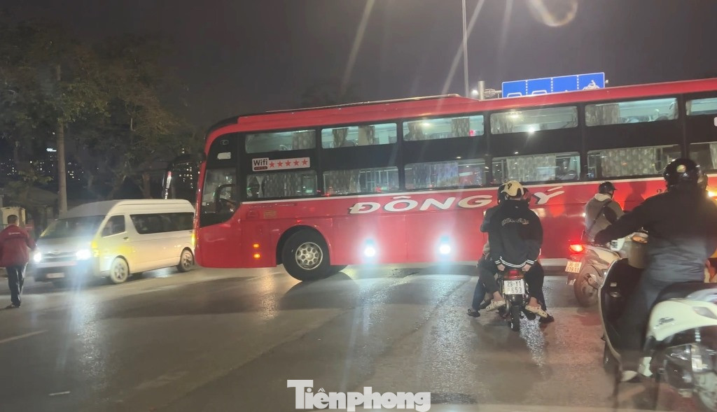 Nhân viên nhà xe đứng giữa đường "xi nhan" cho xe khách 36B-01235 sang đường.