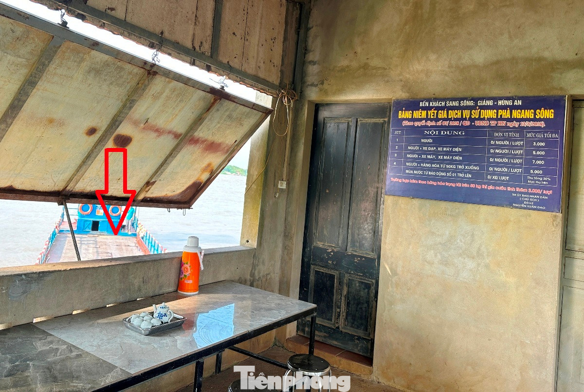 Bên trong nhà điều hành phà Giáng vẫn có bảng niêm yết giá dịch vụ đưa người, xe qua sông, dưới sông là phà nổ máy đứng chờ khách (mũi tên)