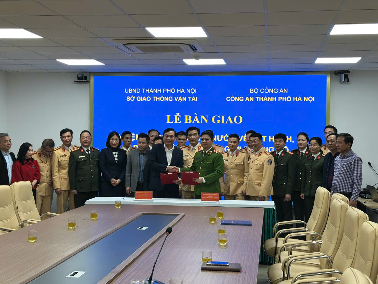 Phó Giám đốc Sở GTVT Hà Nội Đào Duy Phong và Phó Giám đốc Công an thành phố Hà Nội - Thiếu tướng Dương Đức Hải trao biên bản bàn giao với sự chứng kiến của cán bộ hai đơn vị.