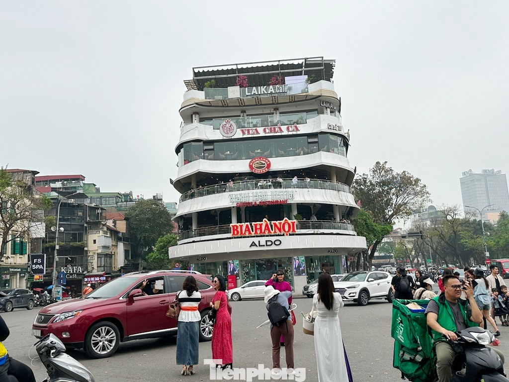 Một số người dân điều khiển ô tô đi qua khu vực quảng trường Đông Kinh - Nghĩa Thục khi đến đoạn trước tòa nhà Hàm cá mập đã dừng, đỗ lại (vi phạm biển cấm) để chụp ảnh.