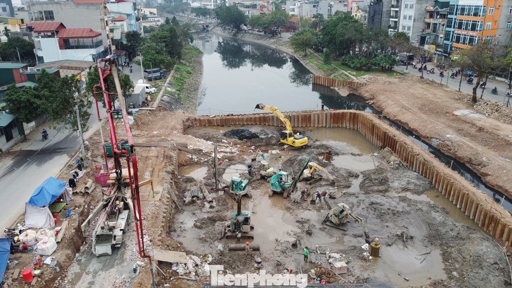 Trong lòng phạm vi hàng rào khoanh tròn trên sông Tô Lịch các đơn vị thi công đang huy động máy móc, nhân lực đào sâu để đổ móng làm đập dâng. Trong lòng phạm vi hàng rào khoanh tròn trên sông Tô Lịch các đơn vị thi công đang huy động máy móc, nhân lực đào sâu để đổ móng làm đập dâng.