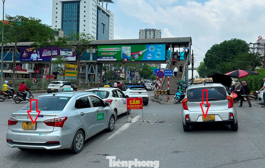 Hàng loạt taxi đeo biển taxi truyền thống (taxi hãng) và taxi công nghệ (chạy grab) đều che biển khi đứng bắt khách "chợ" (khách vẫy xe trên đường) trước cổng bệnh viện Bạch Mai.