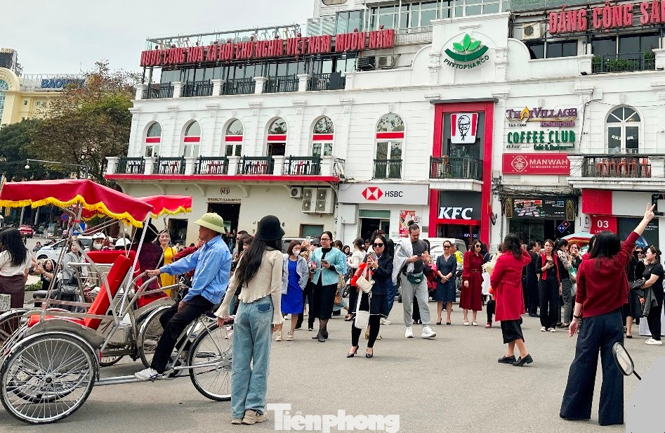 Lượng người và khách du lịch đứng ngã năm quảng trường Đông Kinh - Nghĩa Thục để chụp ảnh, check in sau khi có thông tin tòa nhà sẽ phá dỡ trước dịp 30/4.