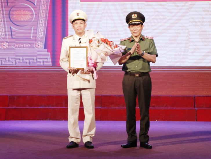 Đại tá Tạ Văn Đẹp (bìa trái) nhận quyết định