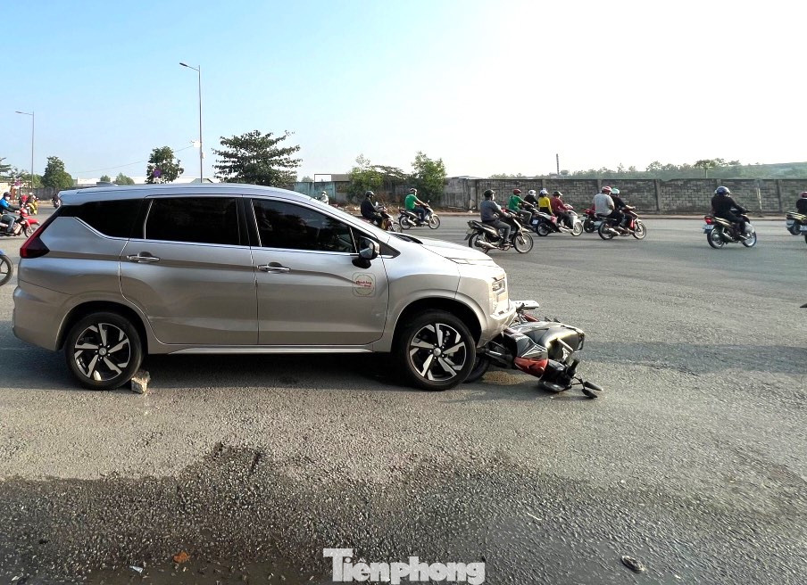 Một chiếc xe máy đang bị mắc kẹt dưới đầu xe ô tô