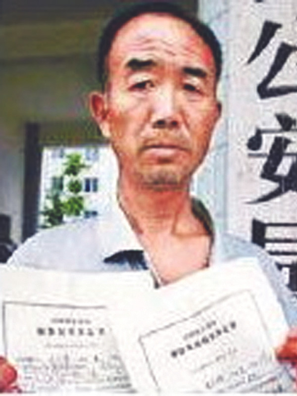 Lão ông Wu Zhifeng cầm quyết định bắt giam và quyết định thả tự do tại cổng cơ quan cảnh sát địa phương. Ảnh: China Daily