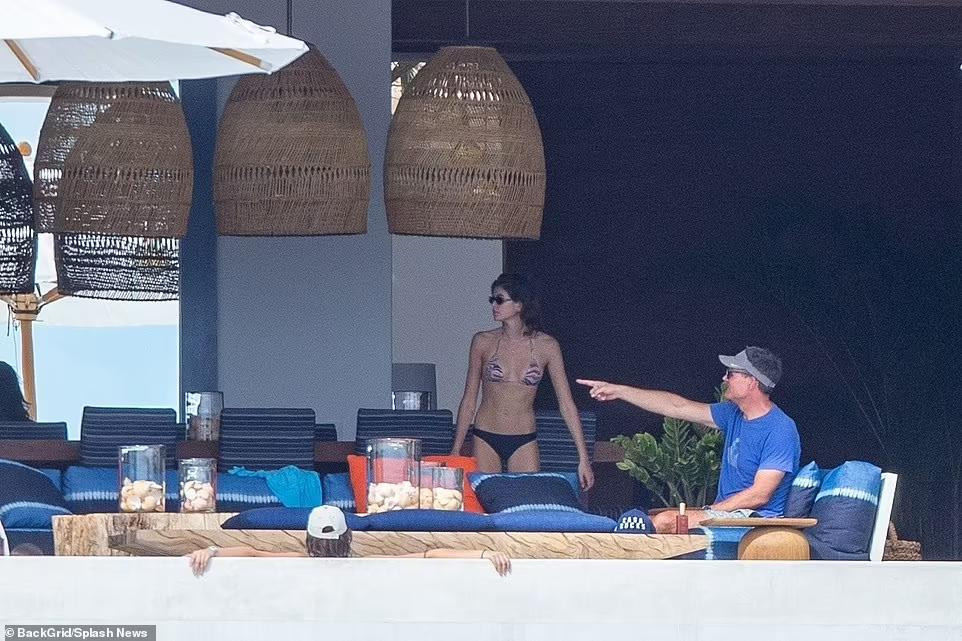 Kaia Gerber được bố Rande Gerber đang chỉ về phía trước nói điều gì đó.