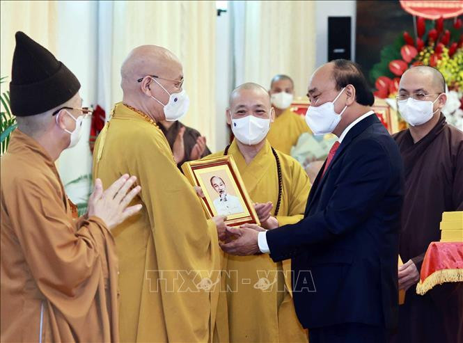 Chủ tịch nước Nguyễn Xuân Phúc tặng chân dung Chủ tịch Hồ Chí Minh cho các đại biểu. Ảnh: Thống Nhất/TTXVN