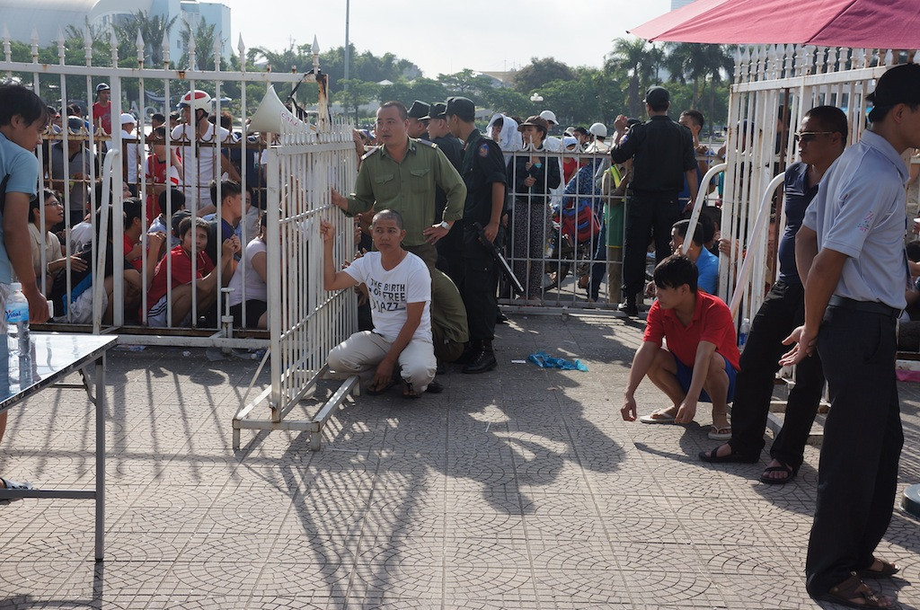 Khi thấy các PV phát hiện vụ chen ngang và chĩa ống kính máy ảnh, nhân viên an ninh lập tức lấy xe chở nhân vật này sang cửa phát tích kê khác