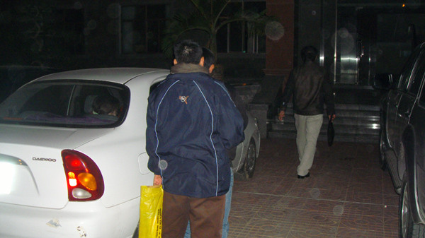 Chưa đầy 10 phút sau,chiếc xe lăn bánh vào sân trụ sở Cơ quan CSĐT tại đại lộ 3-2. Người xách túi màu vàng là thân nhân, đang cố gắng che chắn cho ông Thắng, tránh bị chụp ảnh