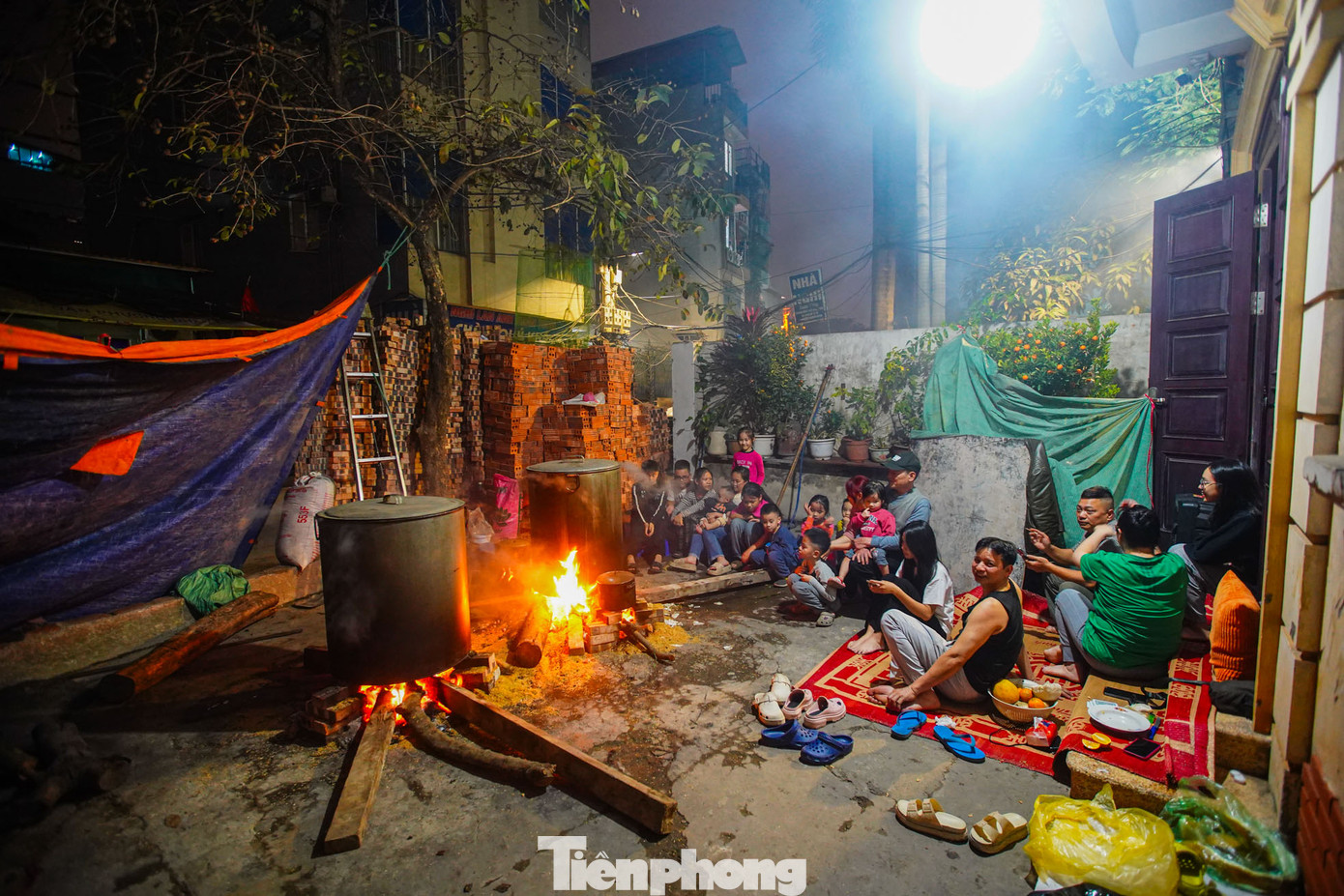 Tại một góc sân trong ngõ 342 Khương Đình (quận Thanh Xuân), chị Hồng Tâm cùng với gia đình gồm ba thế hệ nhiều con cháu cùng nhau thức canh nồi bánh chưng, bếp lửa hồng