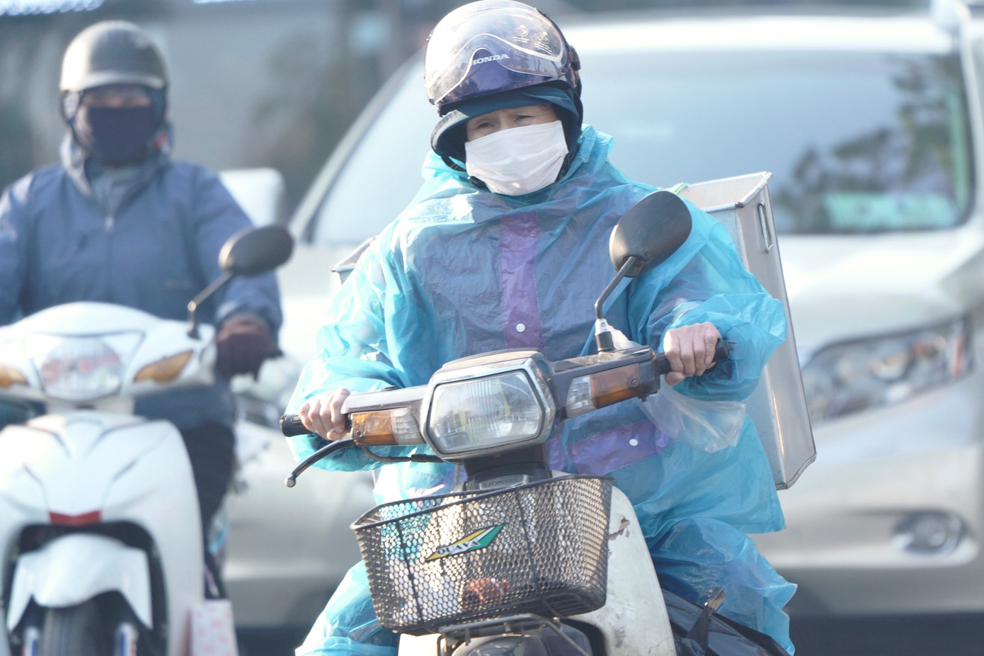 Một số người mặc thêm áo mưa để chống rét.