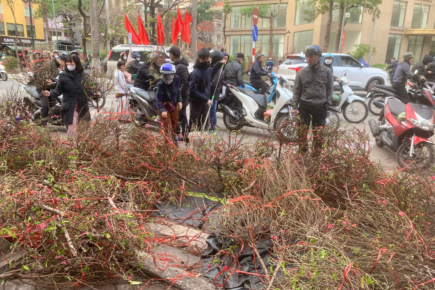 Tiểu thương xả hàng đào cành ngay dưới lòng đường phố Tân Mai (quận Hoàng Mai) với giá 150.000/cành.