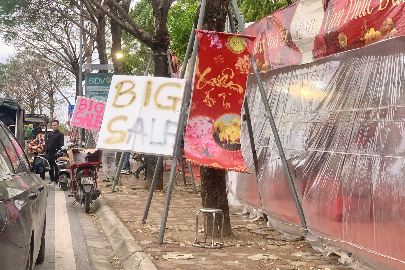 Các gian hàng hoa còn sót lại hạ giá, bán tháo tại chợ hoa Tết ở quận Tây Hồ.