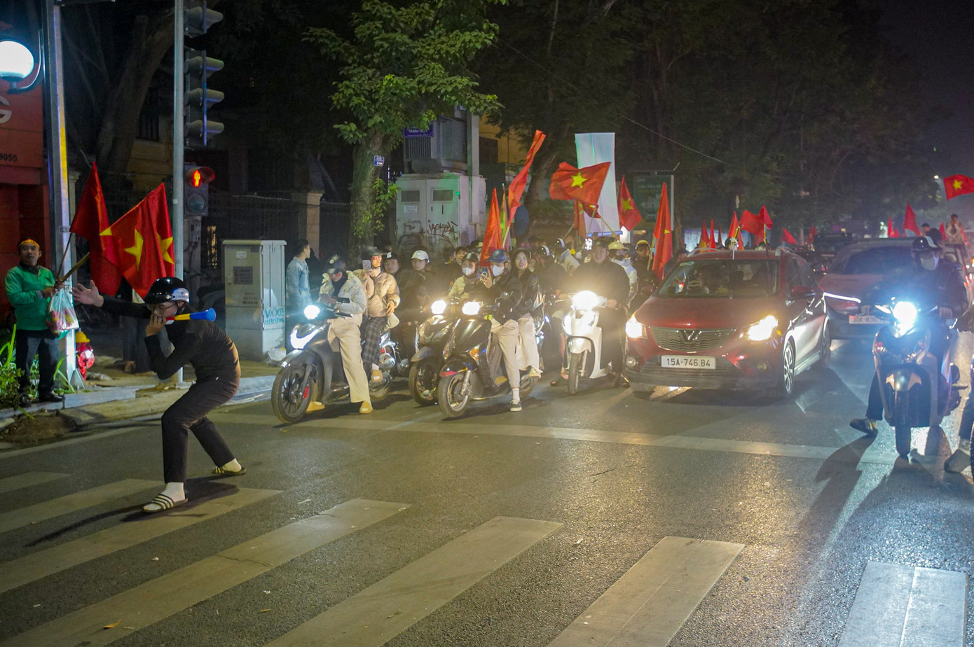 Một cổ động viên tranh thủ xuống đường ăn mừng trong thời gian chờ đèn đỏ.