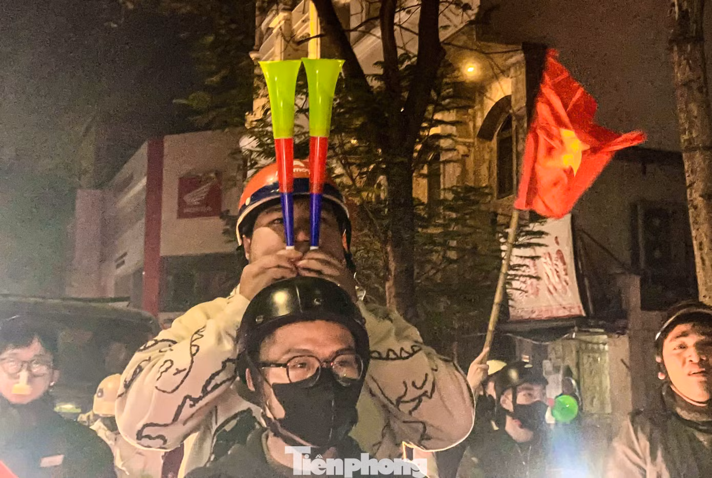 CĐV ăn mừng cuồng nhiệt bằng cách thổi hai kèn cùng một lúc.