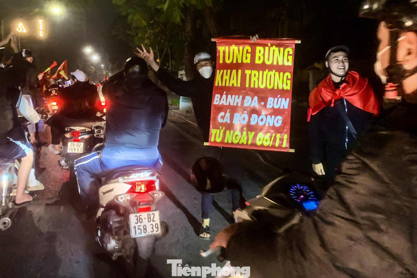 Người hâm mộ mang biển khai trương ra đường quảng cáo với dòng phương tiện. Người hâm mộ mang biển khai trương ra đường quảng cáo với dòng phương tiện.