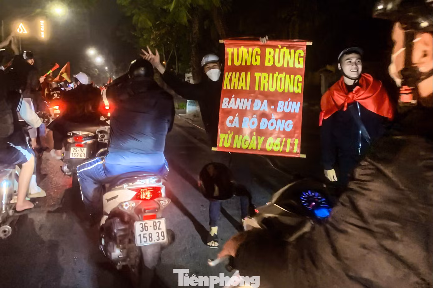 Người hâm mộ mang biển khai trương ra đường quảng cáo với dòng phương tiện.