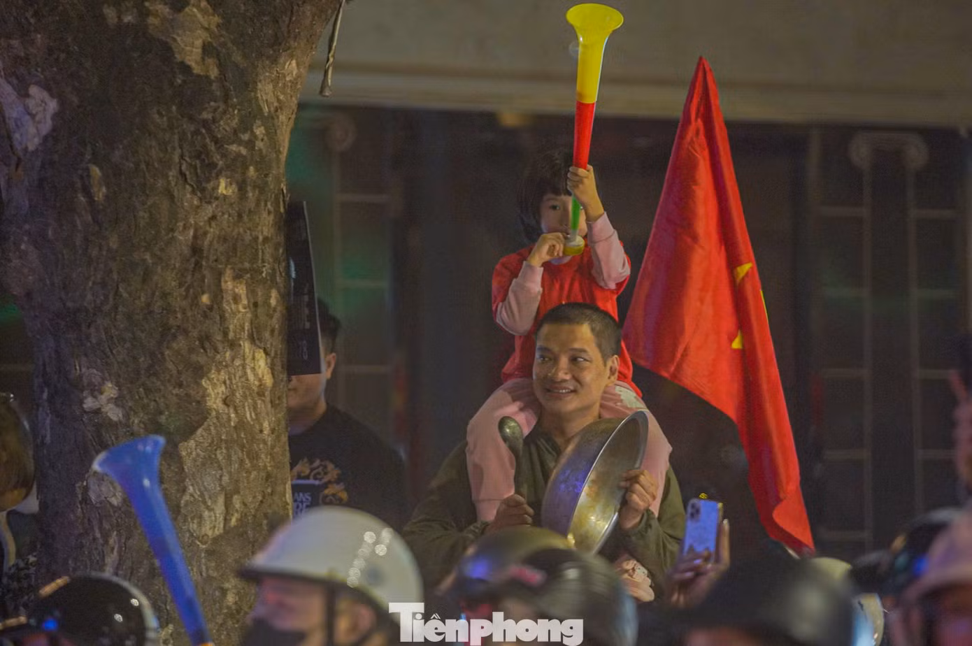Một cổ động viên cầm muôi và chậu ra đường ăn mừng chiến thắng.