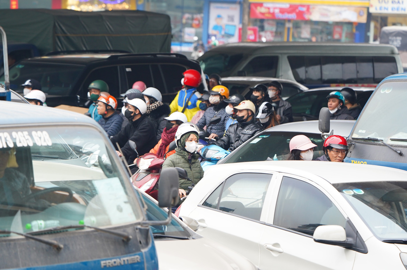 Xe máy mắc kẹt giữa các làn xe ô tô.