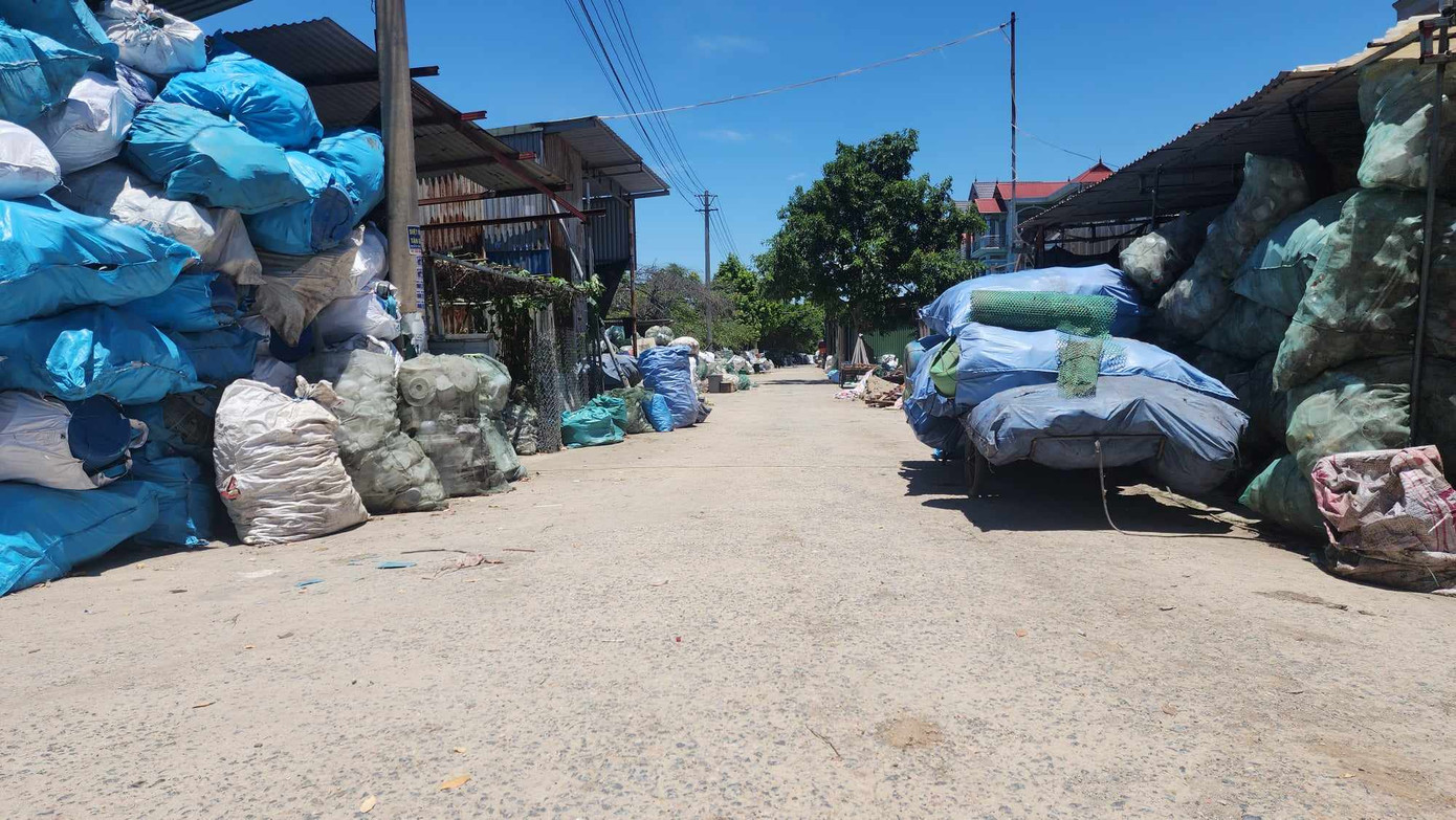 Vật liệu tái chế được người dân thu gom, phân loại xếp hai bên đường vào làng