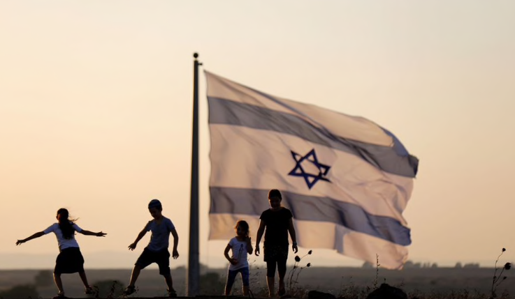 Trẻ em Israel chơi gần lá cờ cắm ở khu vực biên giới giữa Israel và Syria. (Ảnh: Reuters)
