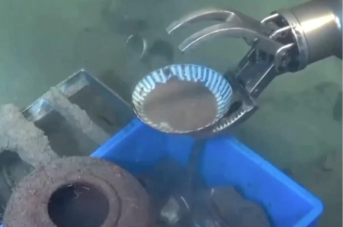 Cánh tay robot vớt một hiện vật bằng sứ trong chuyến khảo cổ dưới đáy Biển Đông mà Trung Quốc thực hiện. (Ảnh: CCTV)