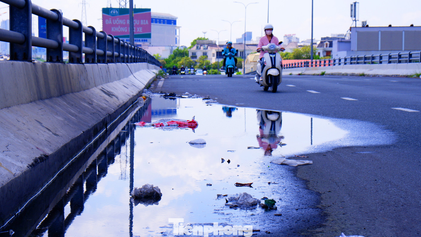 Nước đọng thành vũng chiếm gần một phần làn đường. Nhiều người khi điều khiển xe máy qua khu vực phải né tránh vũng nước, điều này tiềm ẩn rủi ro tai nạn giao thông. Nước đọng thành vũng chiếm gần một phần làn đường. Nhiều người khi điều khiển xe máy qua khu vực phải né tránh vũng nước, điều này tiềm ẩn rủi ro tai nạn giao thông.