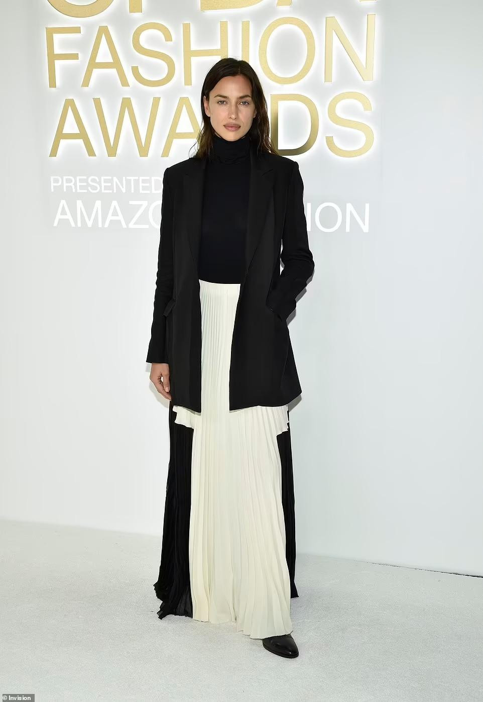 Siêu mẫu Irina Shayk nữ tính với áo cổ lọ, váy xếp ly và blazer cơ bản. Cô vừa tái hợp với người yêu cũ Bradley Cooper. Ảnh: Invision.