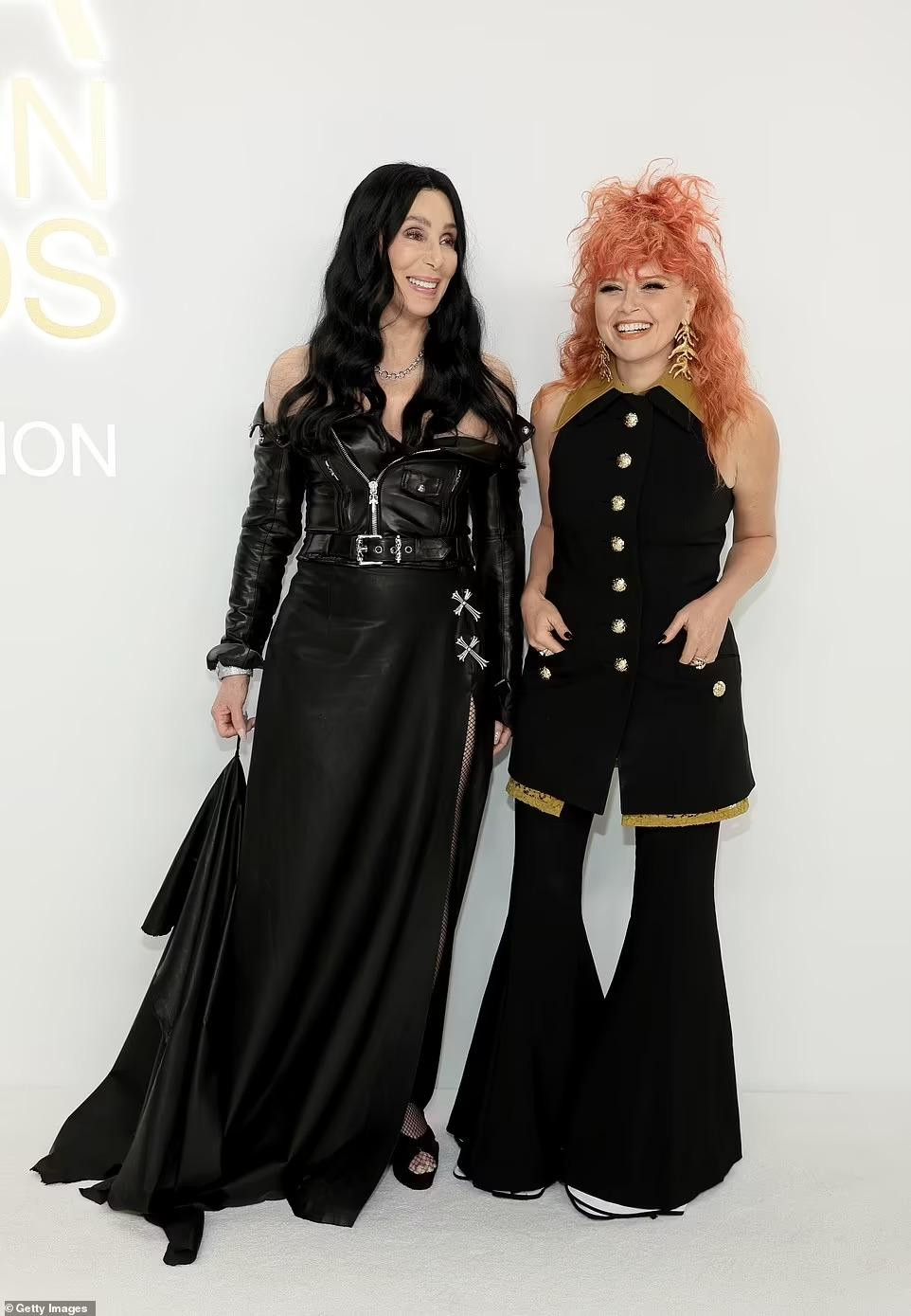 Danh ca 76 tuổi Cher đầy cá tính khi kết hợp áo da trễ vai và chân váy dài xẻ đùi. Trong khi đó, MC của sự kiện, Natasha Lyonne, khác biệt với mái tóc rối màu cam và quần ống loe. Ảnh: Getty Images.