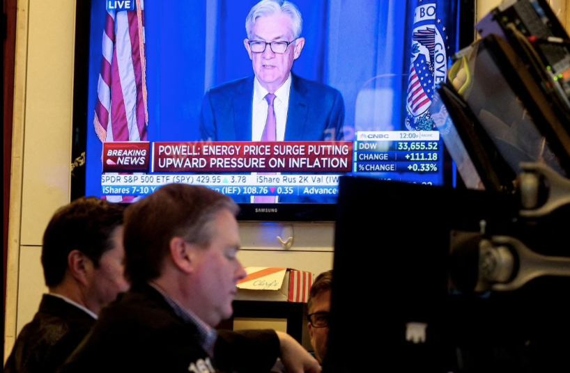 Hình ảnh chủ tịch Fed Jerome Powell được phát trên màn hình tại sàn chứng khoán New York khi thông báo về việc tăng lãi suất. (Ảnh: Reuters)