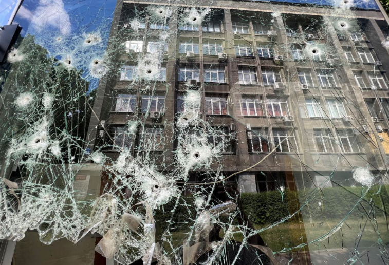 Cửa sổ một cửa hàng bị thủng lỗ chỗ ở Kharkiv ngày 23/5. (Ảnh: Reuters)