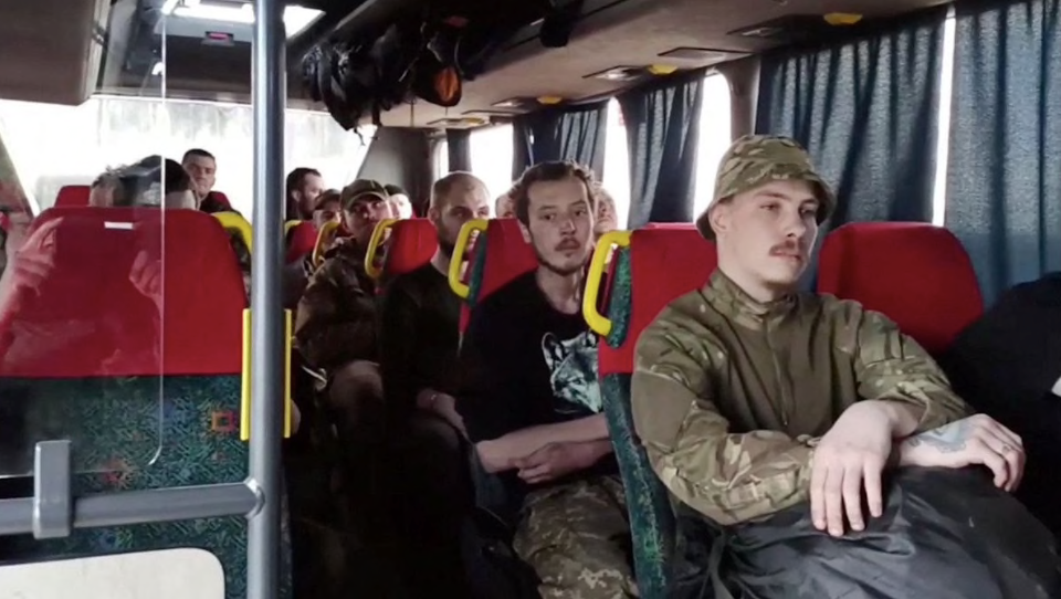Ảnh cắt từ một video do Nga công bố ngày 17/5 cho thấy nhóm binh lính đầu hàng ở nhà máy thép Azovstal đang ngồi trên xe buýt để rời khỏi thành phố Mariupol
