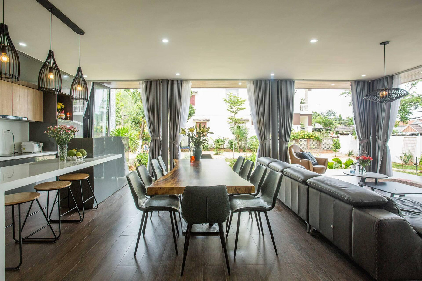 Khu đầu tiên của ngôi nhà là phòng sinh hoạt chung. Cách bố trí mặt bằng mở đơn giản và thông thoáng, các góc tiếp khách, phòng ăn và bếp được liên thông với nhau.