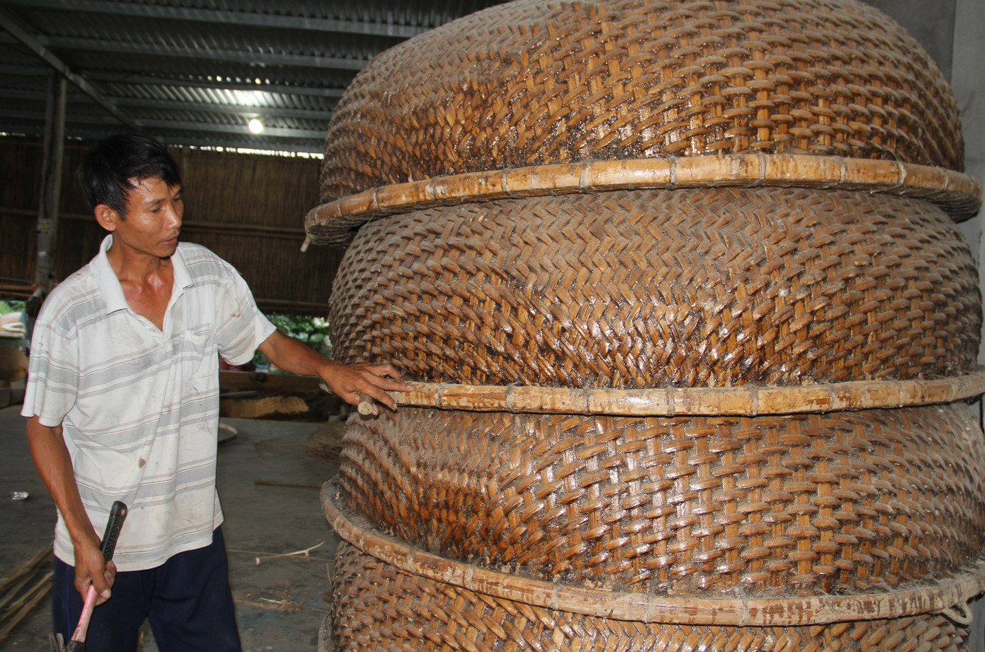 Ông Trương Văn Trung tỉ mỉ nắn lại vành thúng chai trước khi đem bán. Ảnh: Công Hoan