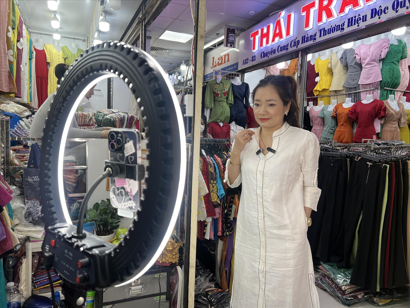 Nhân viên sạp quần áo Thái Trang livestream bán hàng tại chợ An Đông Ảnh: U.P Nhân viên sạp quần áo Thái Trang livestream bán hàng tại chợ An Đông Ảnh: U.P