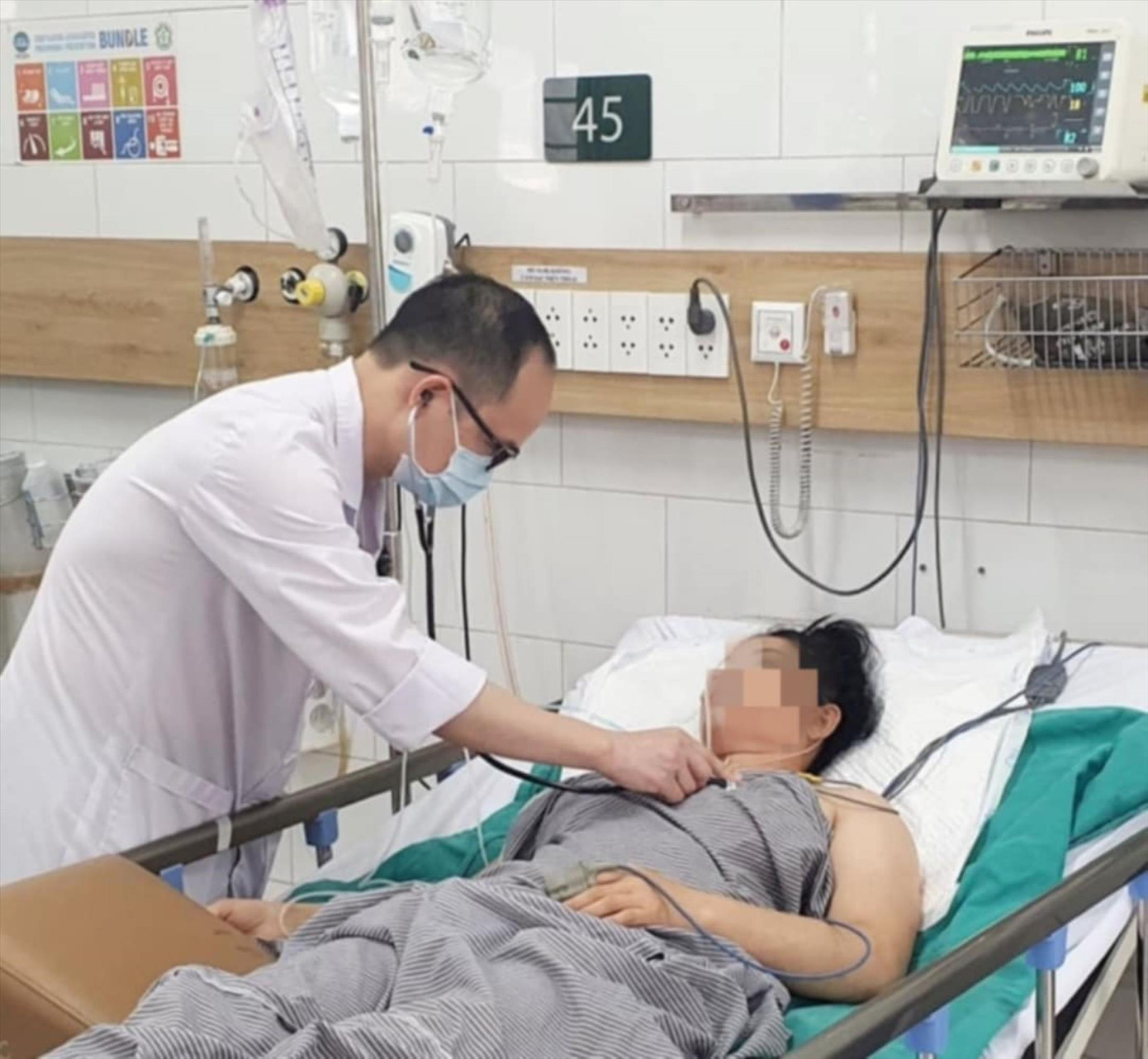 Bác sĩ khám cho người mẹ trong gia đình có 3 người hôn mê vì khí CO.