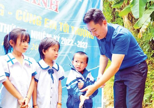 Anh Lê Văn Lương, Bí thư Tỉnh Đoàn Nghệ An khoác chiếc áo mới cho học sinh tại bản Khủn Na, xã Đồng Văn, huyện Quế Phong, Nghệ An. Ảnh: Cảnh Huệ