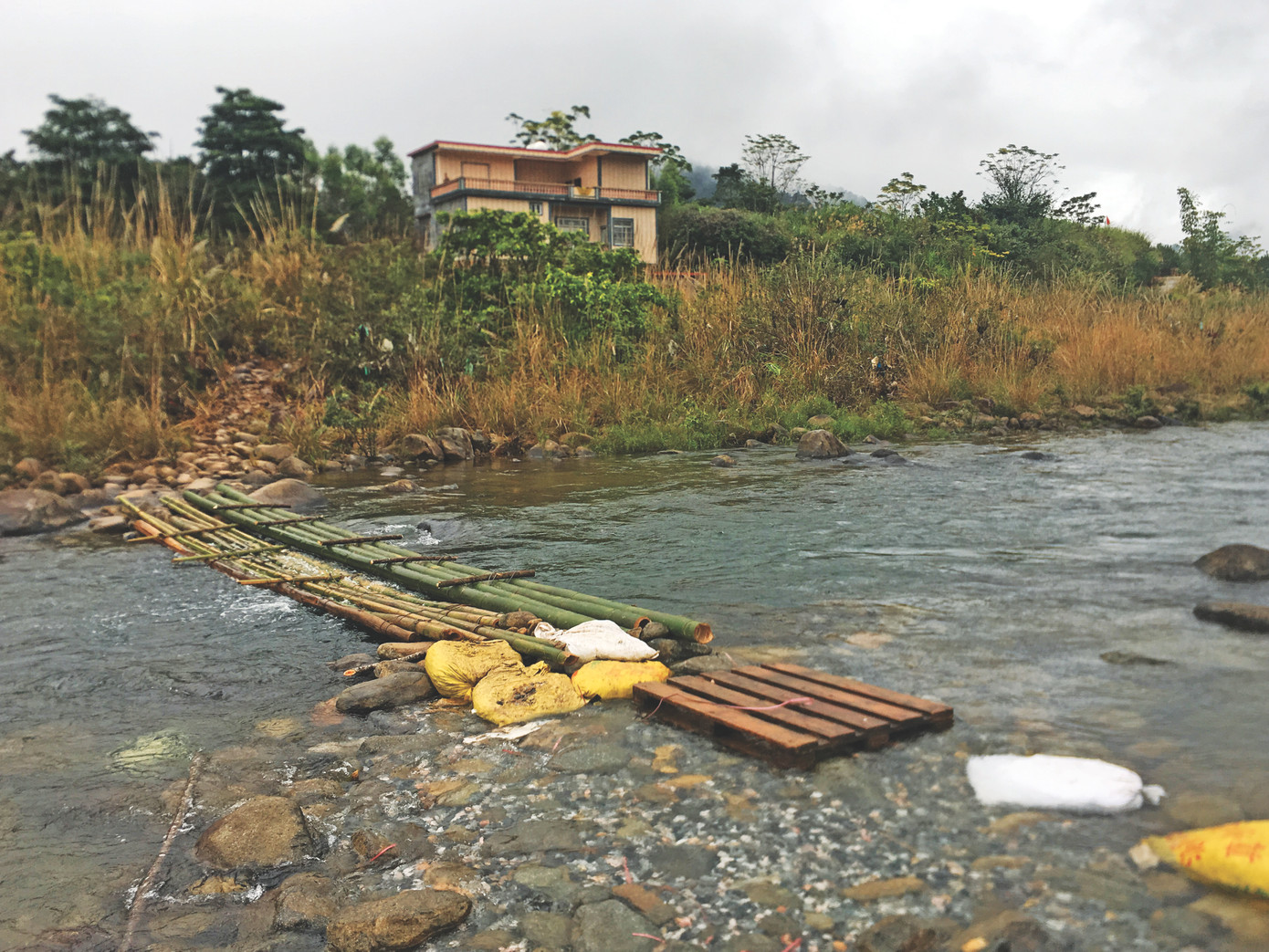 Cầu tre tạm qua suối để vận chuyển hàng lậu, và một nhà dân lắp đầy camera phía bên Trung Quốc để cảnh giới.
