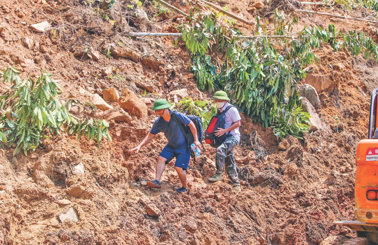 Phóng viên Viết Hà, Hân Nguyễn đi bộ vào tác nghiệp tại Nậm Tông