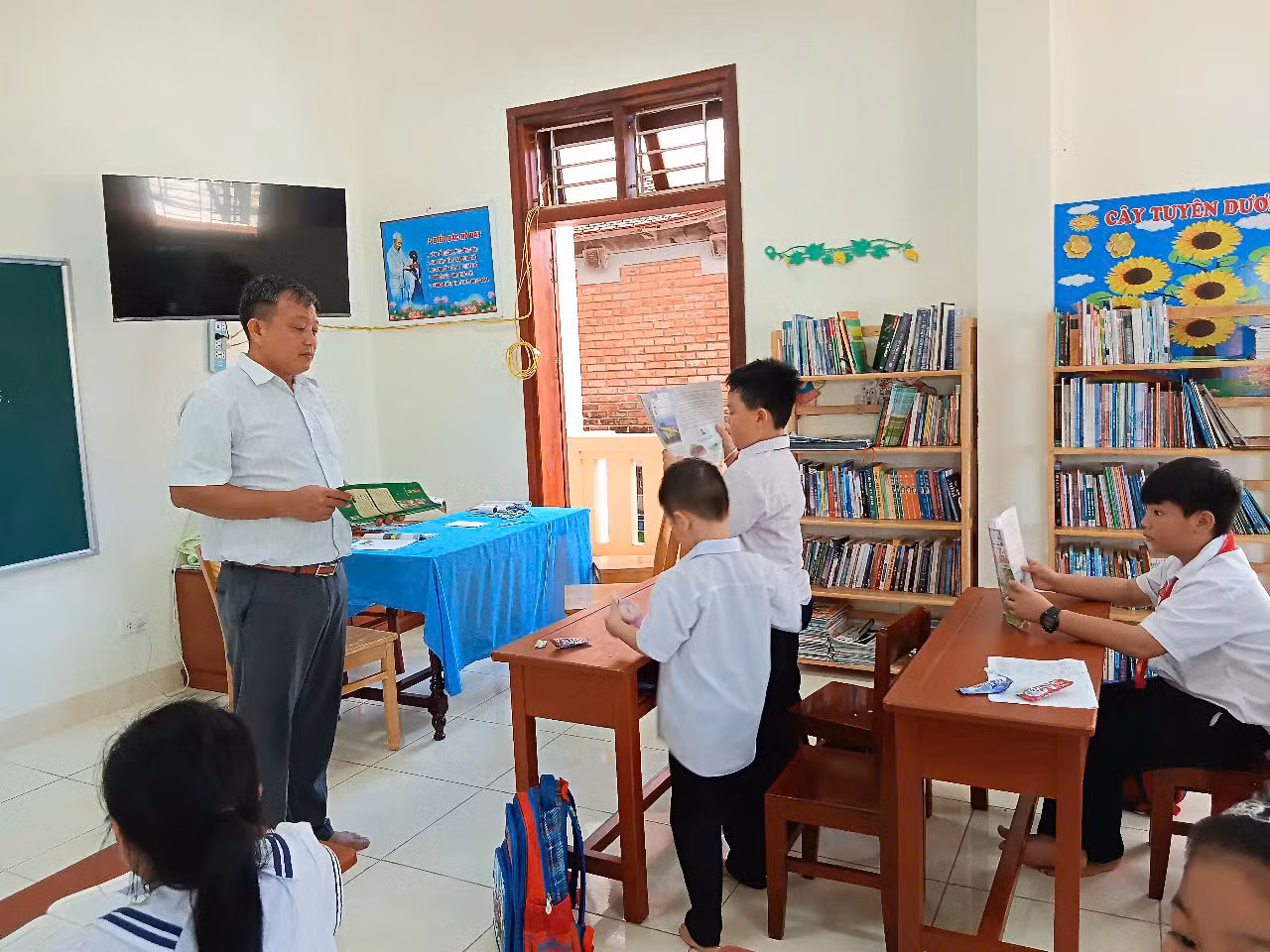 Thầy Thịnh đang hướng dẫn các học sinh nhiều trình độ của mình cách tóm tắt một câu chuyện trong sách